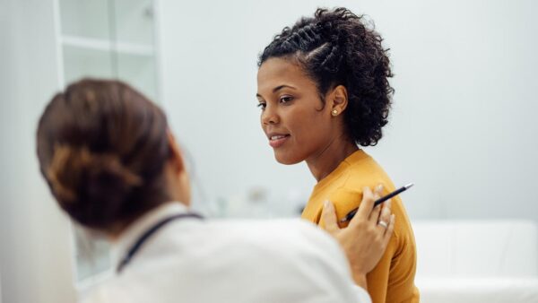 Physician reassuring female patient.