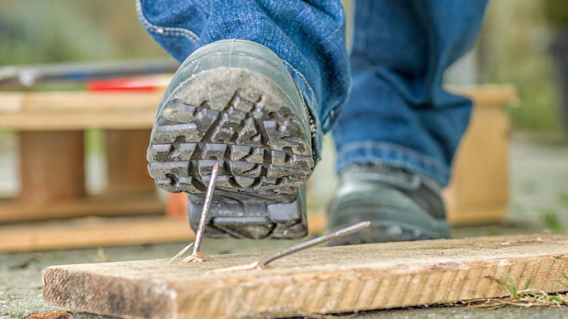 Worker stepping on nail.