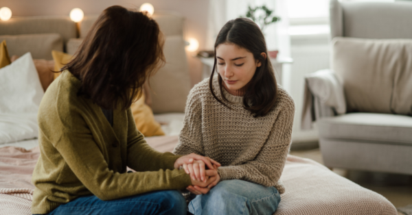 Teenage girl sharing problems with her mother in the room.