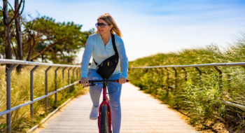 Mid adult woman riding bicycle at seaside