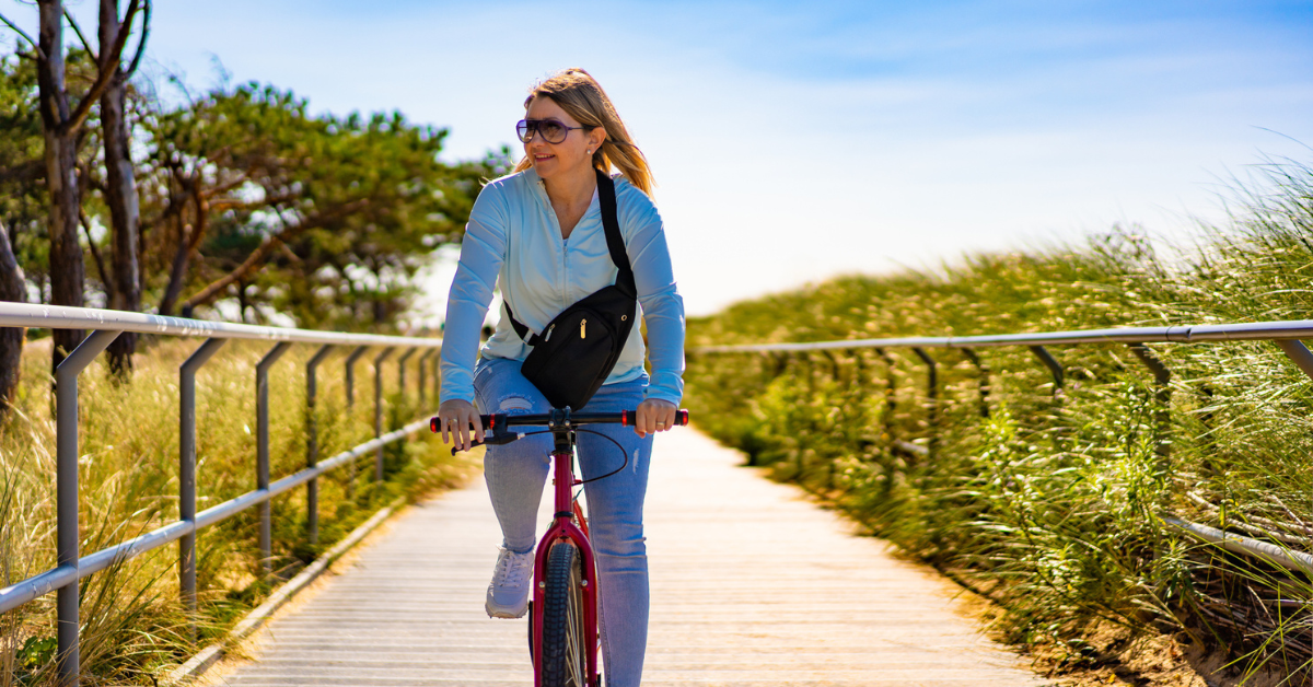 Mid adult woman riding bicycle at seaside