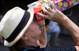 A person looking at the eclipse using a cereal box