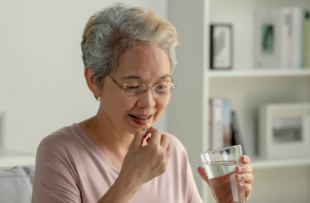 senior woman taking medicine at home