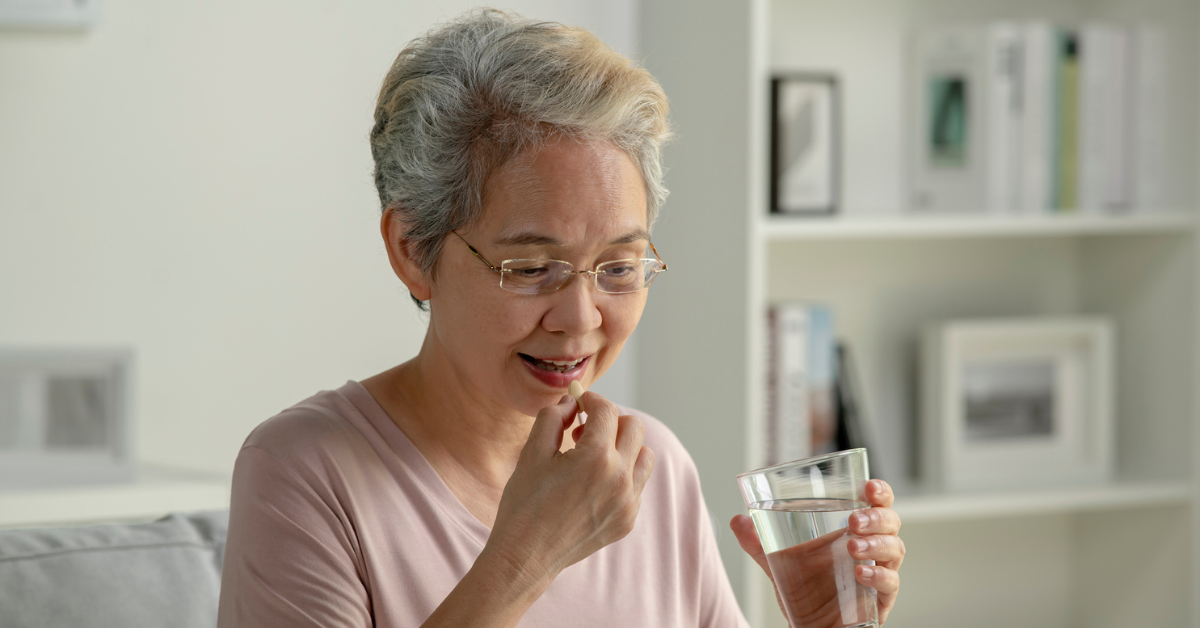 senior woman taking medicine at home