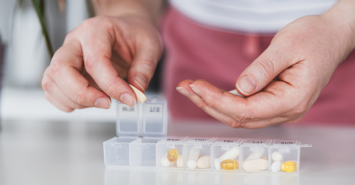 Closeup of medical pill box with doses of tablets for daily take a medicine with different white, yellow drugs and capsules