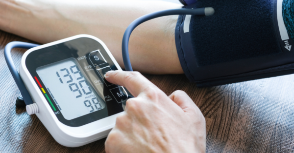 Man checks blood pressure monitor and heart rate monitor with digital pressure gauge.