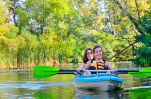 mother and child paddling in kayak on river canoe tour