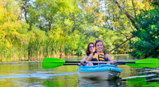 mother and child paddling in kayak on river canoe tour