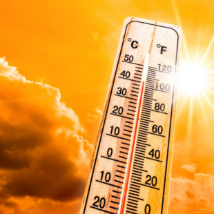 Hot summer or heat wave background, glowing sun on orange sky with thermometer