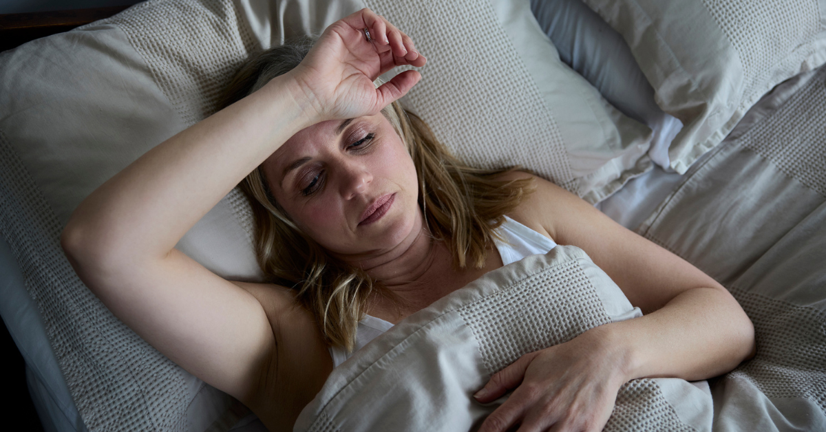 Menopausal Mature Woman Suffering With Insomnia In Bed At Home