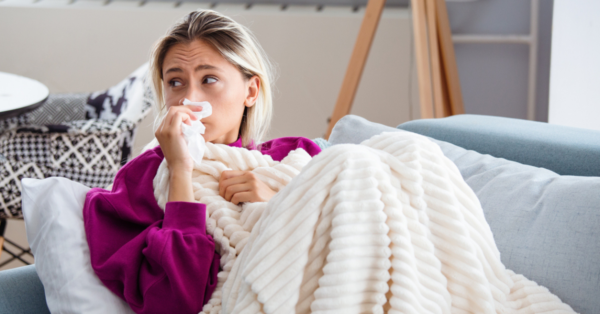 Young Woman Infected With Cold Blowing Her Nose In Handkerchief.