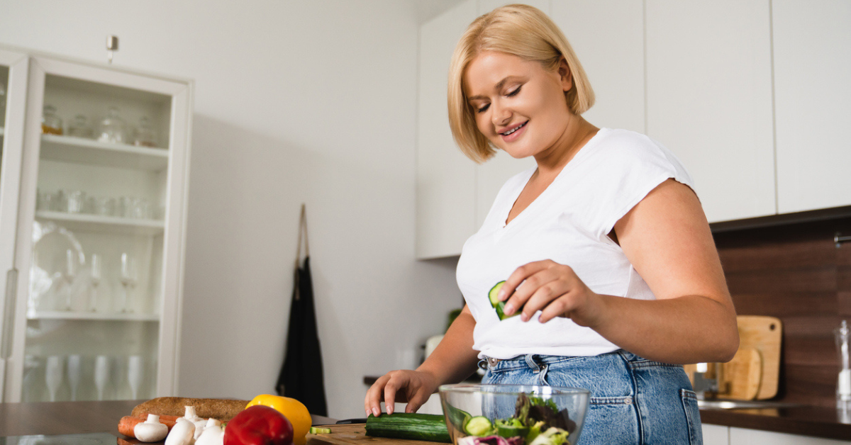 Young caucasian woman cooking making salad, healthy food.