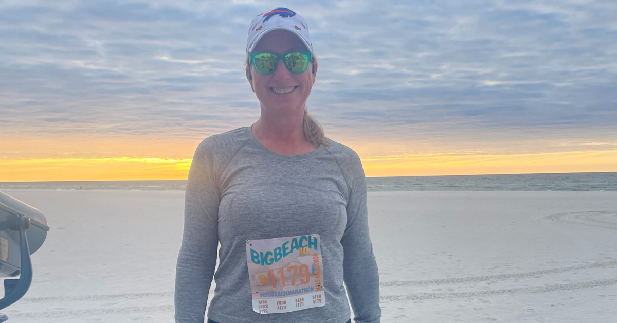 Lisa Hadwin stands on a beach after completing a half marathon.