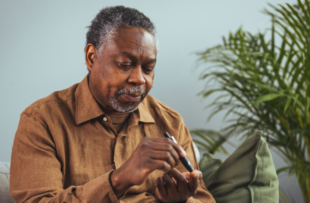 man hands using lancet on finger to check blood sugar or ketones level by glucose meter.