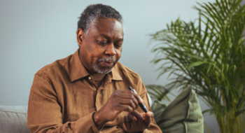 man hands using lancet on finger to check blood sugar or ketones level by glucose meter.