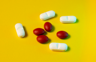 White and red pills on a yellow background. Top view.