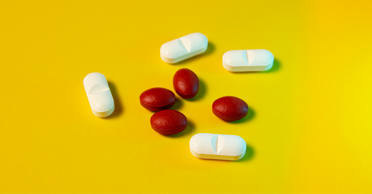 White and red pills on a yellow background. Top view.