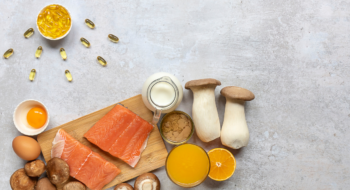 Flat lay composition with products rich in vitamin D. Canned tuna, mushrooms, salmon, eggs, milk, and orange juice - great natural sources of Vitamin D.