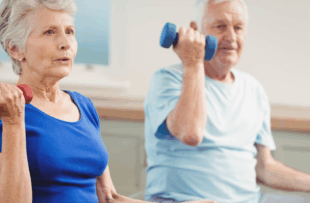 An older man and woman lifting weights while sitting down.