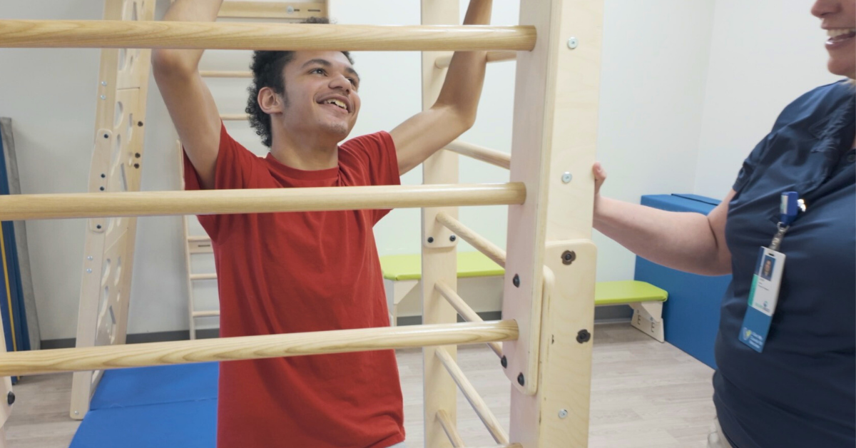 16-year-old boy learns and plays on new equipment that resembles monkey bars.