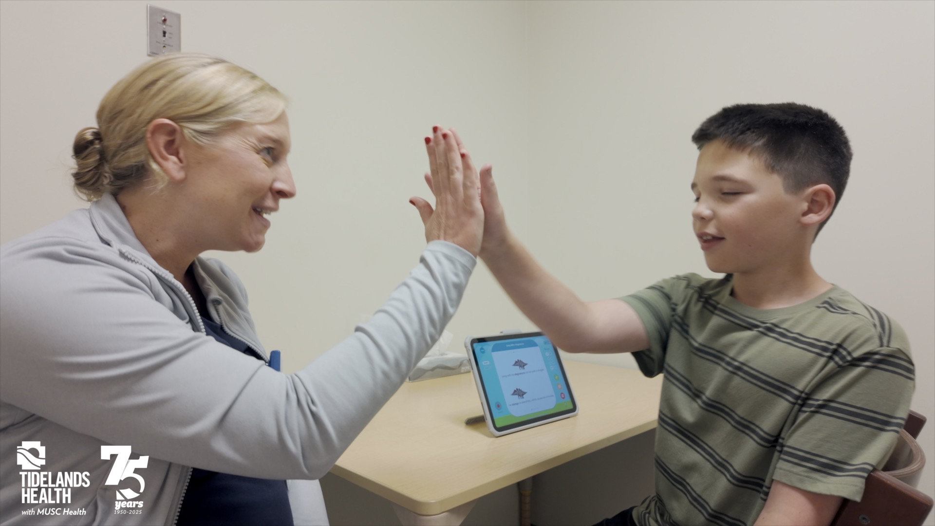 A little boy and therapist high-fiving