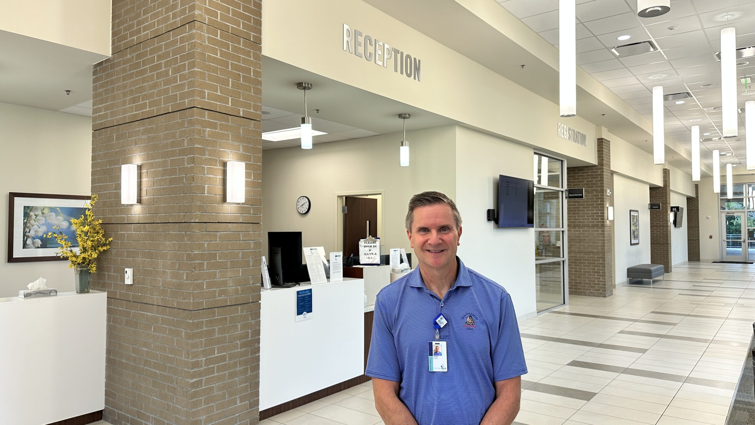 David Burker smiling in front of the registration desk
