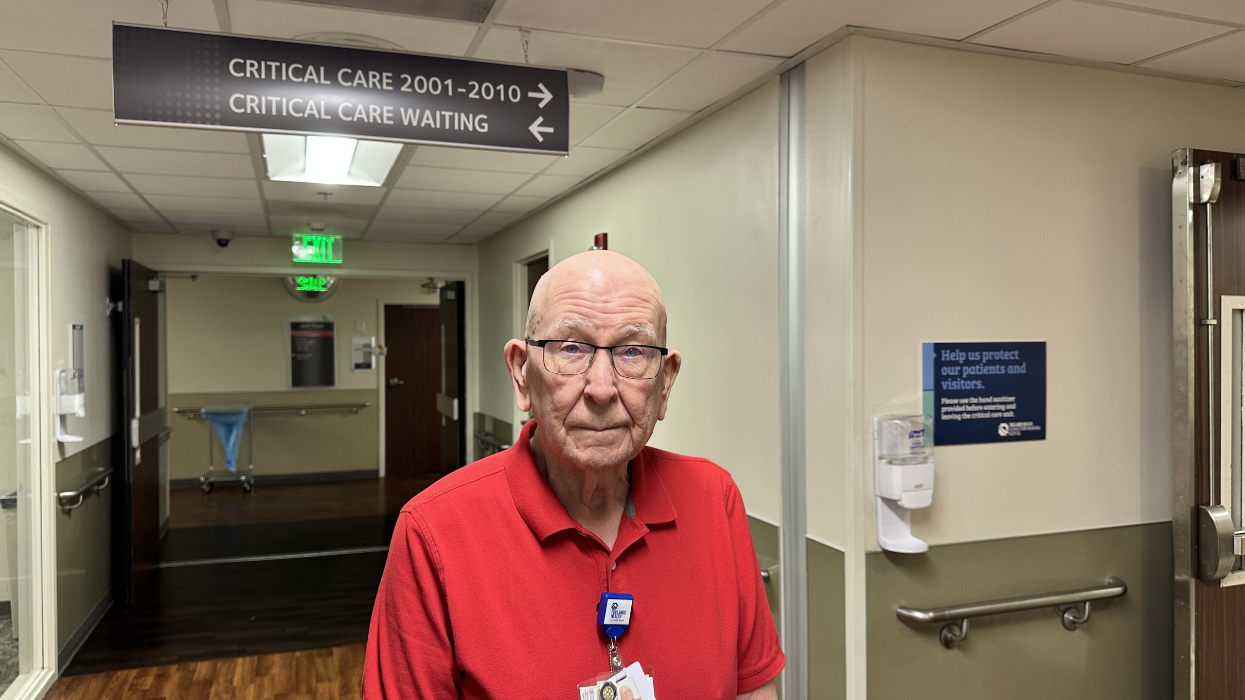 Charles Clark standing in front of the critical care unit sign