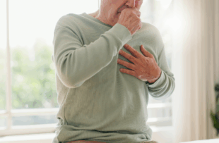 Coughing, sick and a person feeling chest for pain, heart attack or health problem at home.