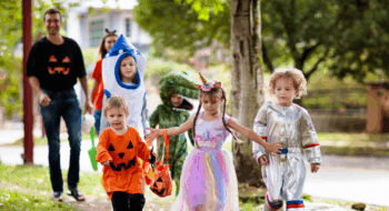 Little boy and girl with pumpkin lantern and candy bucket. Baby in witch hat. Autumn holiday fun.