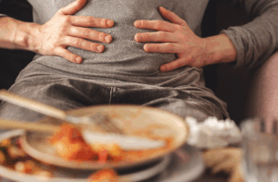 Woman with bloating and stomach pain after eating