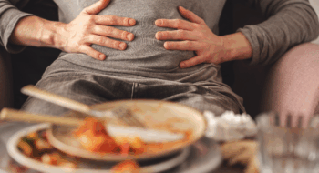 Woman with bloating and stomach pain after eating