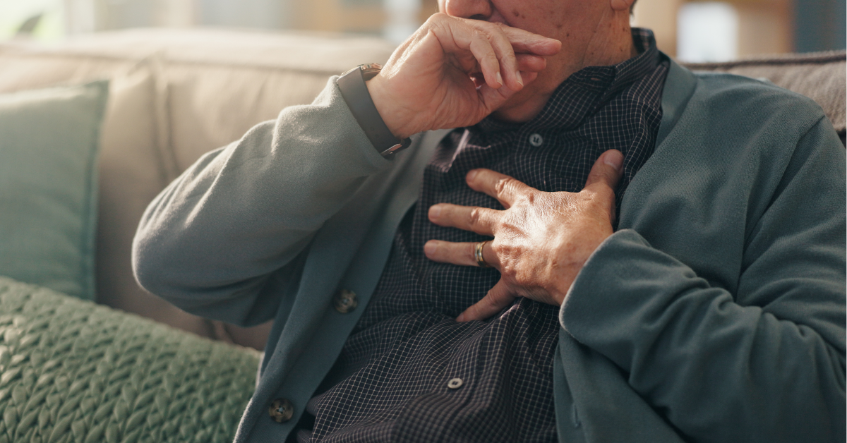 Home, hands and old man with chest pain, cough and cardiac symptoms in lounge. Closeup, hypertension or elderly person with heart attack signs, retirement and viral infection with illness or asthma